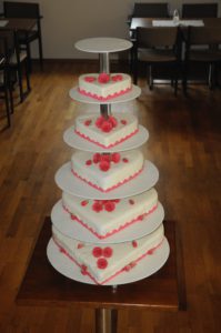Herztorten mit Rollfondant eingeckt auf klassischem Hochzeitstortenständer